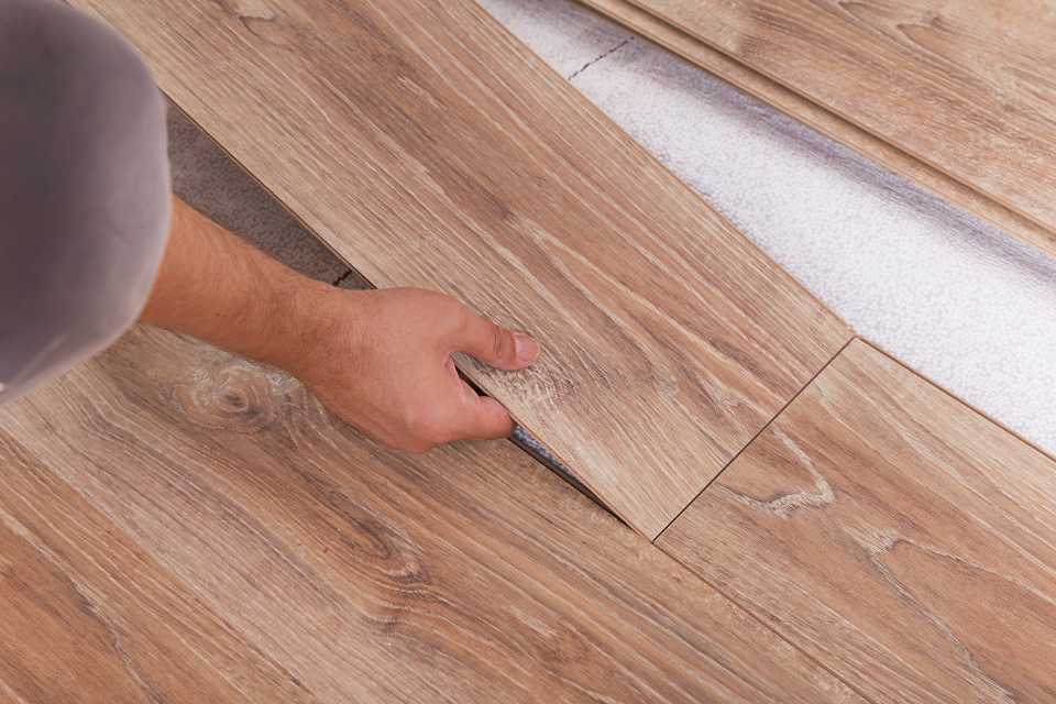 professional flooring installer laying down luxury vinyl floors
